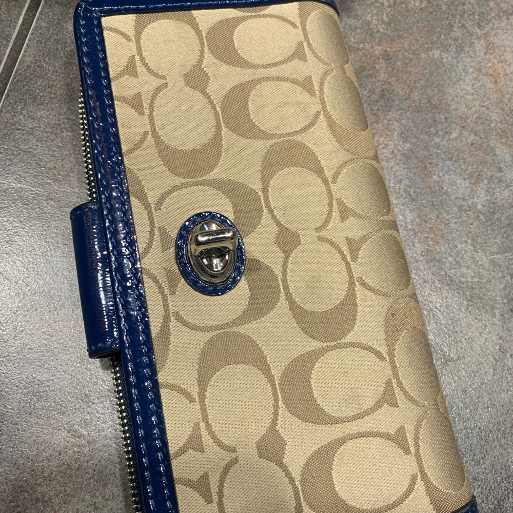 Coach bifold wallet with navy blue trim and  turn-lock closure